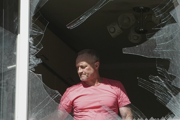 A man looks at broken window in his house after a Russian drone and missile attack in Kyiv, Ukraine, Friday, July 4, 2025. (AP Photo/Efrem Lukatsky)