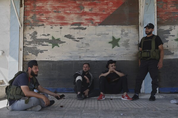 Bedouin fighters on a road in Ezraa village on the outskirts of Daraa city, after clashes erupted between the beduin clans and Druze militias in Sweida province, southern Syria, Friday, July 18, 2025. (AP Photo/Ghaith Alsayed)