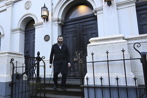 Rabbi Dovid Gutnick walks past damage to the exterior of the East Melbourne Hebrew Congregation in Melbourne, Saturday, July 5, 2025, after an arsonist set fire to the door. (James Ross/AAP Image via AP)