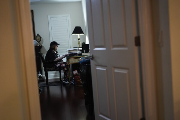 Shelly Newman, 73, who uses a walker due to impaired balance, makes canvassing calls to other Villagers to encourage voter turnout, in her bedroom in The Villages, Fla., Sunday, Sept. 15, 2024. Newman and her husband moved to The Villages in 2013. "When we moved here, we were more concerned about being Democrat than being Jewish," said Newman. (AP Photo/Rebecca Blackwell)