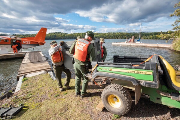 This Sept. 26, 2018 file photo provided by the National Park Service shows NPS staff unloading a crated gray wolf from a United States Fish & Wildlife Service aircraft at Isle Royale National Park in Michigan. (National Park Service via AP)