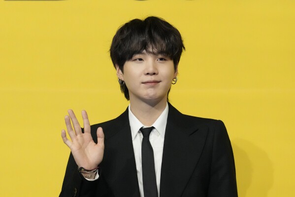Suga, a member of South Korean K-pop band BTS, poses for photographers ahead of a press conference to introduce their new single "Butter" in Seoul, South Korea on May 21, 2021. (AP Photo/Lee Jin-man, File)