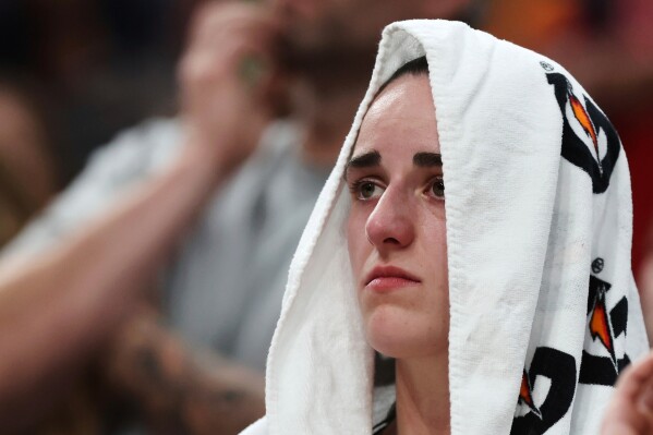 Indiana Fever's Caitlin Clark sits on the bench after an apparent injury during the second half of a WNBA basketball game against the Connecticut Sun, Tuesday, July 15, 2025, in Boston. (AP Photo/Michael Dwyer, File)
