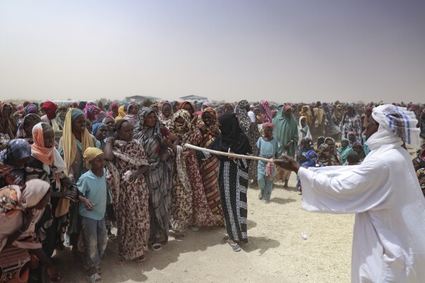 Refugees wait for food distribution at the Tine transit camp in Chad's Wadi Fara province Saturday, May 3, 2025. (AP Photo/Caitlin Kelly)
