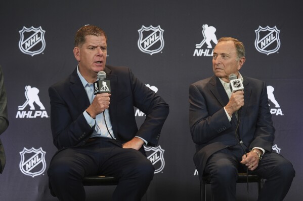 Marty Walsh, left, NHLPA Executive Director, and Gary Bettman, NHL Commissioner, conduct a joint press conference before the NHL hockey draft Friday, June 27, 2025, in Los Angeles. (AP Photo/Damian Dovarganes)