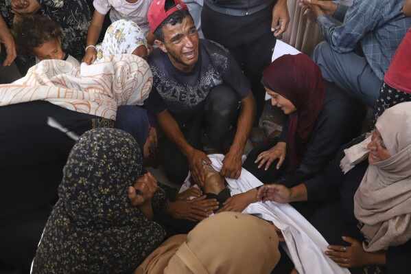 Palestinian relatives mourn over the body of a man killed in an Israeli strike, at Nasser Hospital in Khan Younis, southern Gaza Strip, Tuesday, June 17, 2025. (AP Photo/Mariam Dagga)