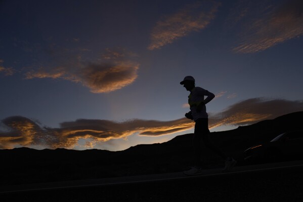 Danny Westergaard runs as the sun rises during the Badwater 135 Ultramarathon, Wednesday, July 9, 2025, near Lone Pine, Calif. (AP Photo/John Locher)