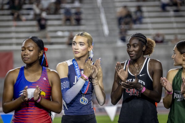 AB Hernandez, center, claps with Kira Gant Hatcher, right, during a medal ceremony for the triple jump at the California high school track-and-field championships in Clovis, Calif., Saturday, May 31, 2025. (Stephen Lam/San Francisco Chronicle via AP)