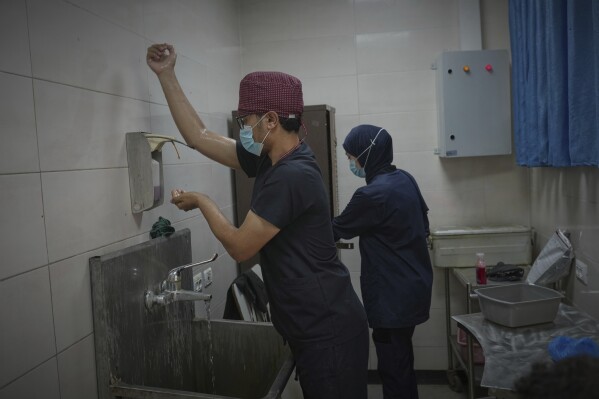 Dr. Jamal Salha sterilizes his hands before entering the operating room at Shifa Hospital in Gaza City, Monday, July 7, 2025. (AP Photo/Jehad Alshrafi)