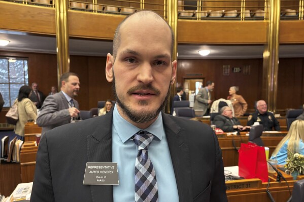 North Dakota Rep. Jared Hendrix, R-Fargo, talks at his desk Wednesday, April 2, 2025, in the House of Representatives at the state Capitol in Bismarck, N.D. (AP Photo/Jack Dura)
