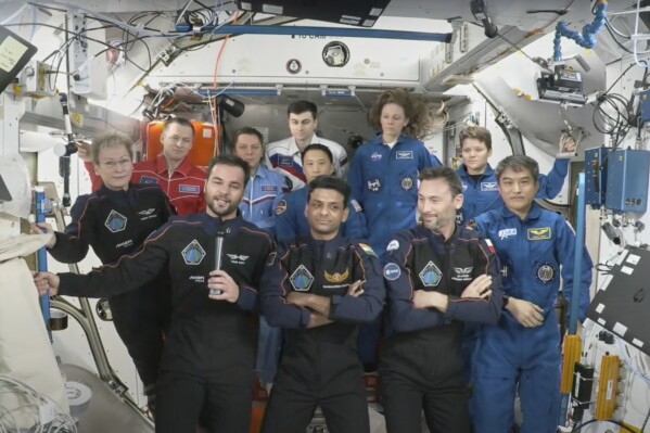 This photo provided by Axiom Space shows the private crew of four, in dark suits, from left, Axiom mission commander Peggy Whitson, Hungary's Tibor Kapu, India's Shubhanshu Shukla and Poland's Slawosz Uznanski-Wisniewski, during a farewell ceremony aboard the International Space Station on Sunday, July 13, 2025. (Axiom Space via AP)