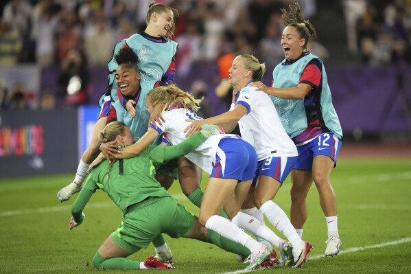 England players run to England goalkeeper Hannah Hampton celebrating after winning a penalty shootout at the end of the Women's Euro 2025 quarterfinals soccer match between Sweden and England at Stadion Letzigrund in Zurich, Switzerland, Thursday, July 17, 2025. (AP Photo/Alessandra Tarantino)