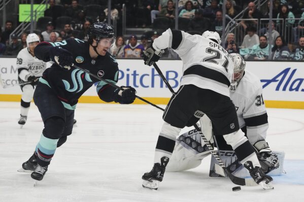 Los Angeles Kings goaltender David Rittich (31) and defenseman Jordan Spence (21) block the puck against Seattle Kraken left wing Tye Kartye, left, during the second period of an NHL hockey game, April 15, 2025, in Seattle. (AP Photo/Lindsey Wasson, File)