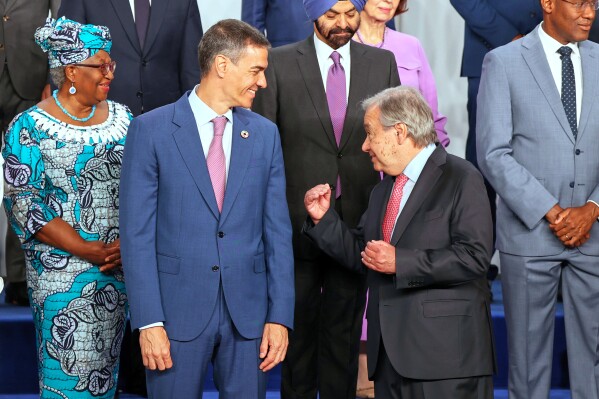 Spain's Prime Minister Pedro Sanchez, left, speaks with United Nations Secretary-General Antonio Guterres, as they pose for a photo with nation leaders and representatives, at the start of the four-day Financing for Development meeting, in Seville, Spain, Monday, June 30, 2025. (AP Photo/Jose Angel Garcia)