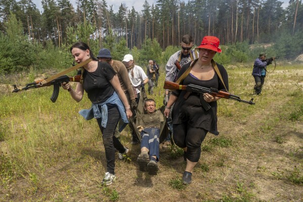 Civilians practice military skills on a training ground in Kharkiv, Ukraine, Saturday, July 12, 2025. (AP Photo/Andrii Marienko)