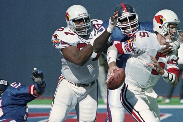 New York Giants Leonard Marshall cuts in front of the Phoenix Cardinals Luis Sharpe (67) to sack quarterback Gary Hogeboom (5) in the fourth quarter of a football game at Giants Stadium in East Rutherford, N.J., Sept. 25, 1989. (AP Photo/Bill Kostroun, File)