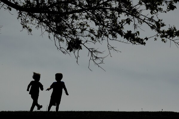 Children run on the lawn at the Liberty Memorial in Kansas City, Mo., on April 28, 2020. (AP Photo/Charlie Riedel, File)