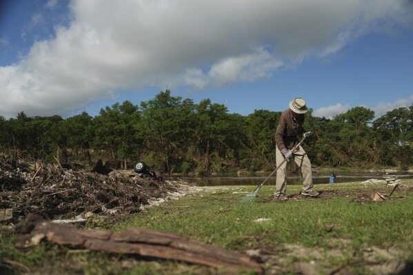 Charles Hanson, 91, cleans up flood debris, Tuesday, July 8, 2025, at Guadelupe Park in Kerrville, Texas. (AP Photo/Joshua A. Bickel)