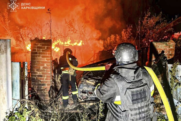 In this photo provided by the Ukrainian Emergency Service, firefighters try to put out a fire following a Russian attack in Kharkiv region, Ukraine, Tuesday, July 15, 2025. (Ukrainian Emergency Service via AP)