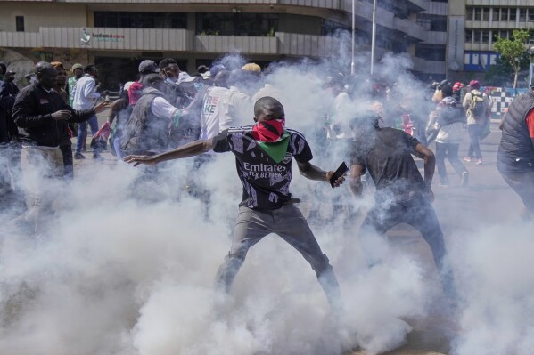 Protesters scatter as police fire teargas at them during a demonstration on the one-year anniversary of deadly anti-tax demonstrations in downtown Nairobi, Kenya, Wednesday, June 25, 2025. (AP Photo/Brian Inganga)