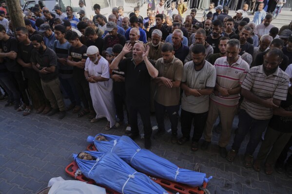 Mourners attend the funeral of victims who were killed in an Israeli bombardment of Gaza Strip, at the Al-Awda Hospital in Nuseirat, on Tuesday, July 8, 2025. (AP Photo/Abdel Kareem Hana)