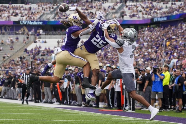 Washington safety Kamren Fabiculanan (13) and cornerback Elijah Jackson (25) break up a pass to Eastern Michigan wide receiver Terry Lockett Jr. (3) in the end zone during the second half of an NCAA college football game Saturday, Sept. 7, 2024, in Seattle. Washington won 30-9. (AP Photo/Lindsey Wasson)