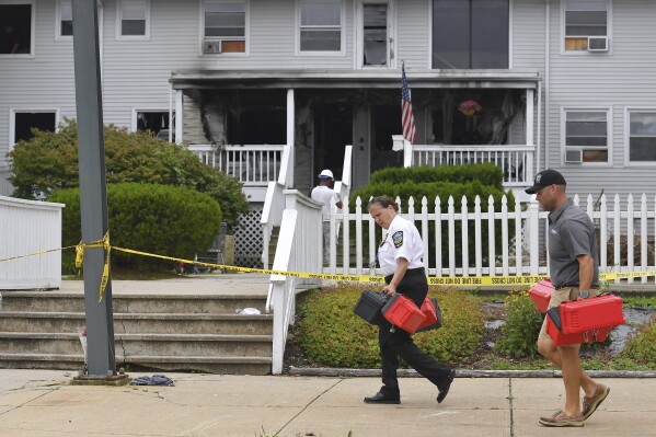 Investigators, front, remove boxes containing patient medications from the Gabriel House assisted living facility, behind, following a fire that resulted in multiple fatalities, in Fall River, Mass., Monday, July 14, 2025. (AP Photo/Steven Senne)