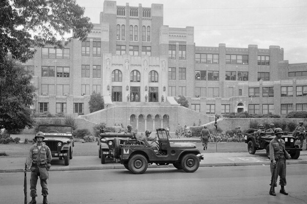 In this Sept. 26, 1957, file photo, members of the 101st Airborne Division take up positions outside Central High School in Little Rock, Ark. (AP Photo/File)