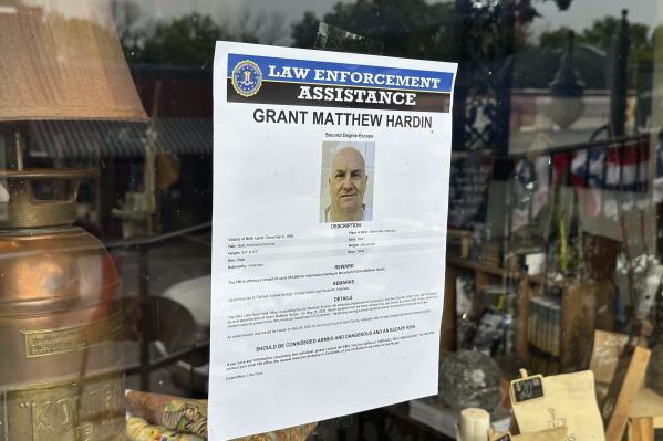 A flier looking for Grant Hardin hangs on the glass of a business, Thursday, May 29, 2025, in downtown Calico Rockt, Ark. (AP Photo/Nicholas Ingram)