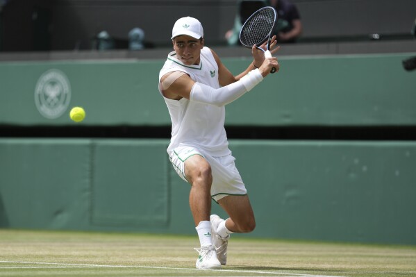 Ivan Ivanov of Bulgaria returns to Ronit Karki of the U.S. in the boys' singles final at the Wimbledon Tennis Championships in London, Sunday, July 13, 2025. (AP Photo/Dave Shopland)