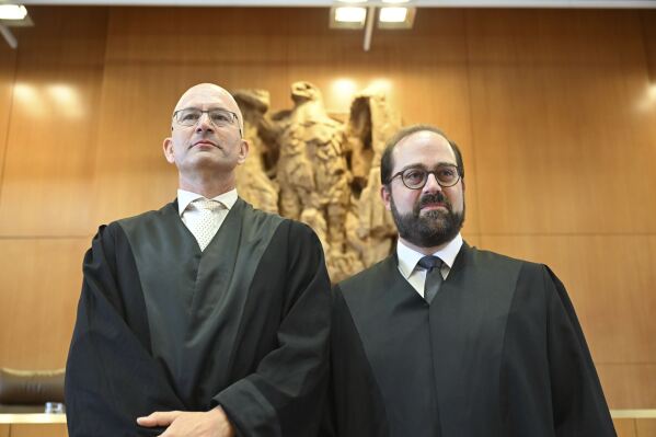 Andreas Schueller, right, and Soenke Hilbrans, lawyers representing the complainants in the proceedings concerning U.S. drone missions via Ramstein, wait in the Federal Constitutional Court for the verdict to be announced, in Karlsruhe, Germany, Tuesday July 15, 2025. (Uli Deck/dpa via AP)
