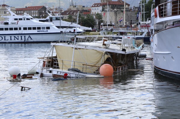 A boat looks submerged in the harbor in Split, Croatia, Tuesday, July 8, 2025, following a powerful storm. (AP Photo/Tom Dubravec)