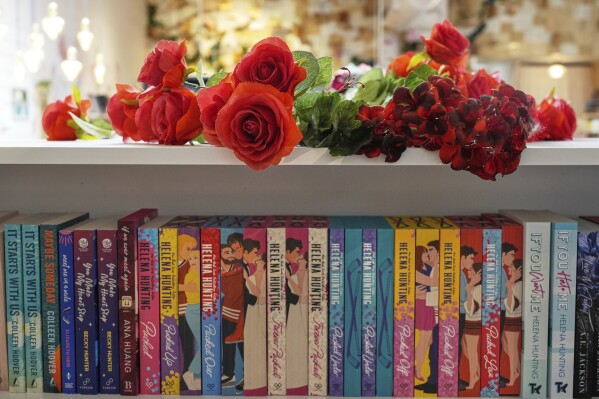 Roses are displayed atop a bookshelf of romance titles at The Ripped Bodice bookstore in Culver City, Calif., on Thursday, July 3, 2025, (AP Photo/Chris Pizzello)