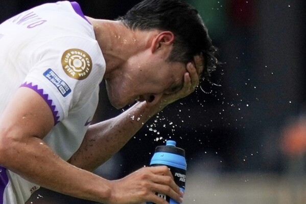 Al Ain's Park Yong-woo splashes his face to cool off during the Club World Cup Group G soccer match between Wydad AC and Al Ain FC in Washington, June 26, 2025. (AP Photo/Julia Demaree Nikhinson, File)