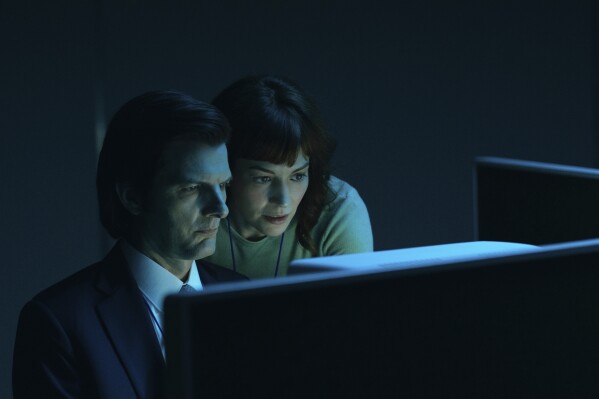 This image released by Apple TV+. shows Adam Scott, left, and Britt Lower in a scene from "Severance." (Apple TV+ via AP)