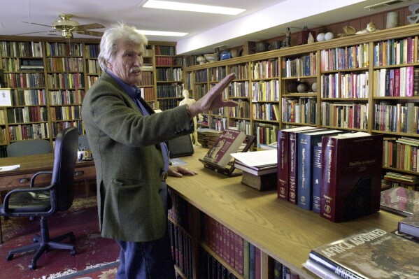 FILE - Schuyler Jones talks about the bookcases he built that line his library Monday, Feb. 6, 2006, in Wichita, Kansas. Jones, a globe-trotting American adventurer whose exploits drew comparisons to iconic movie character Indiana Jones, has died. He was 94. Jones' step-daughter, Cassandra Da'Luz Vieira-Manion, posted on her Facebook page that Jones died on May 17, 2024. (Dave Williams/The Wichita Eagle via AP)