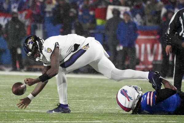 Baltimore Ravens quarterback Lamar Jackson (8) fumbles the football as he is tackled by Buffalo Bills safety Damar Hamlin (3) during the second quarter of an NFL divisional playoff football game, Sunday, Jan. 19, 2025, in Orchard Park, N.Y. (AP Photo/Gene J. Puskar)