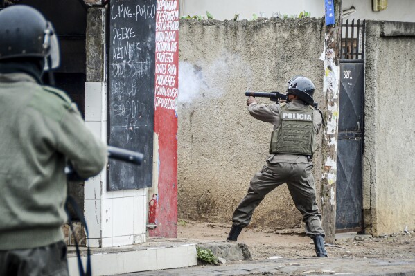 A police officer aims his weapon at protesters in Maputo, Mozambique, Thursday, Nov. 7, 2024. Protesters dispute the outcome of the Oct. 9 elections that saw the ruling Frelimo party extend its 49-year rule. (AP Photo/Carlos Uqueio, file)