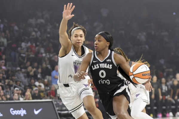Las Vegas Aces guard Jackie Young (0) drives against Golden State Valkyries forward Janelle Salaun, left, during the first half of a WNBA basketball game Saturday, July 12, 2025, in Las Vegas. (Steve Marcus/Las Vegas Sun via AP)