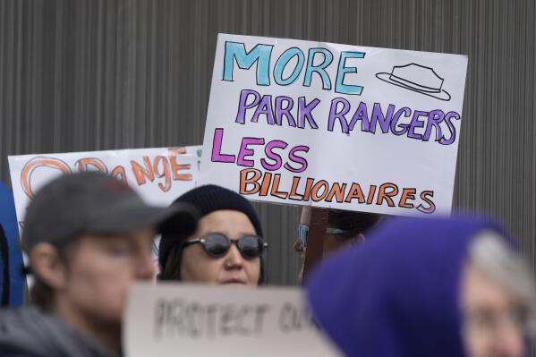 People hold signs during a protest outside the annual Alaska Sustainable Energy Conference, June 3, 2025, in Anchorage, Alaska. (AP Photo/Jenny Kane, File)